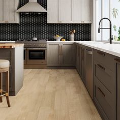 a kitchen with wood flooring and white counter tops next to an island in the middle