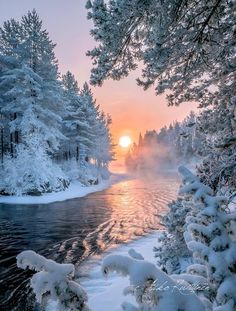 an image of the sun setting over a snowy river