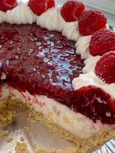 a cake with raspberries and cream on top is cut in half to show the filling