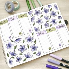 a planner with flowers on it next to some markers