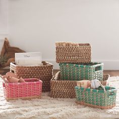 several baskets are stacked on top of each other in front of a white wall and carpet