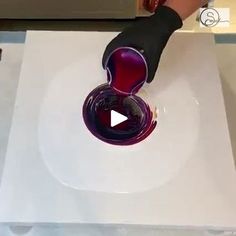 a person is pouring red wine into a glass on top of a white countertop