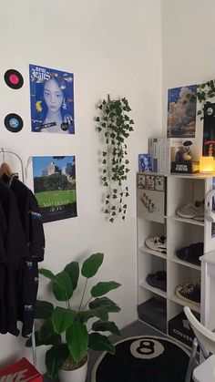 a room with some plants and pictures on the wall