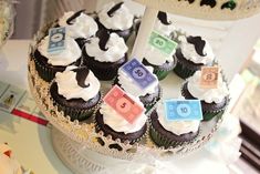 cupcakes decorated with numbers and currency on a cake platter at a baby's first birthday party