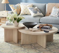 a living room filled with furniture and flowers on top of a coffee table in front of a couch