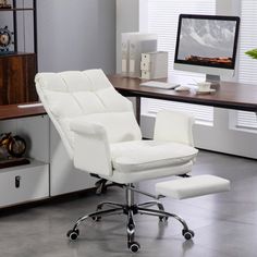 a white office chair sitting in front of a desk with a computer monitor on it