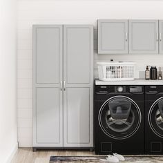 a washer and dryer in a small room with white tile flooring, cabinetry, and cabinets