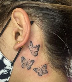 a woman's behind the ear tattoo with three butterflies on her left side neck