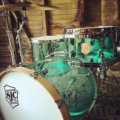 a close up of a green and white drum set in a room with brick walls