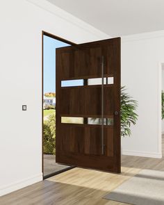 an open wooden door in a white room with wood flooring and potted plant