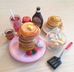 there is a small plate with pancakes on it and other food items next to it