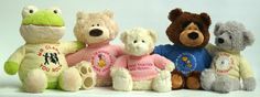 five stuffed animals in different colors and sizes sitting next to each other on a white surface