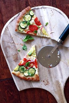 two slices of pizza on a cutting board with a knife