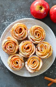 apple cinnamon rolls on a plate with cinnamon sticks