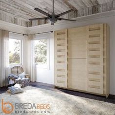 a bedroom with a ceiling fan and wooden closets in it's center area