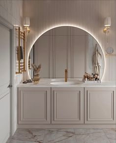 a bathroom with an oval mirror above the sink and two sinks in front of it