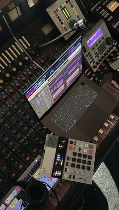 there are many electronic equipment on the table in front of each other, including two laptops and several sound boards