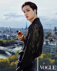 a young man standing on top of a building next to a balcony holding an electronic device