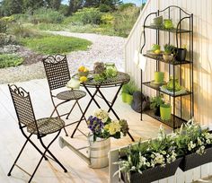 an outdoor table and chairs with potted plants