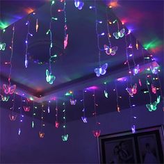 the ceiling is decorated with multicolored lights and butterflies hanging from it's sides