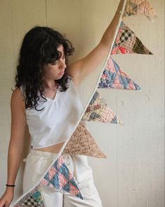 a woman is holding up some colorful triangles