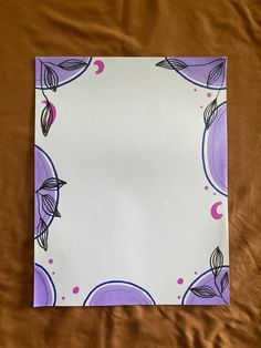 an empty piece of paper on a bed with brown sheets and purple circles around it