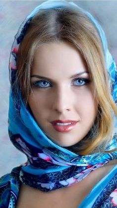 a woman wearing a blue scarf and posing for the camera with her eyes wide open