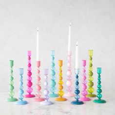 there are many different colored candles in the same row and one candle is on top of each other