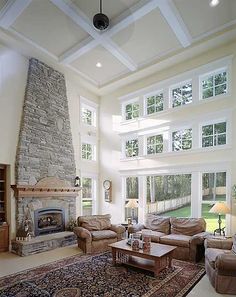 a living room with couches, chairs and a fire place in the middle of it