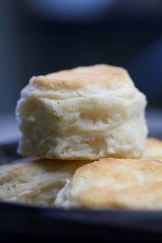 two biscuits are stacked on top of each other in a black plate with a blurry background