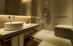 a bathroom with a sink, shower and bathtub is shown in this image at night