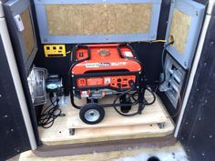 a small portable generator sitting on top of a wooden platform in the back of a truck