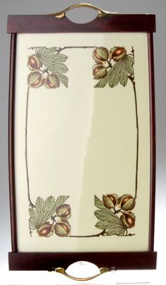 an ornately decorated frame with flowers and leaves on white background, hanging from the wall