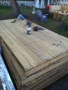 a wooden deck is being built in the yard with tools on it and other woodworking supplies