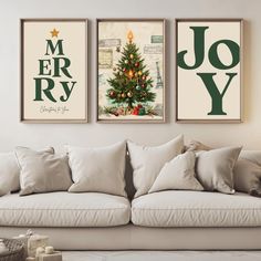 three christmas posters hanging on the wall above a couch in a room with white furniture