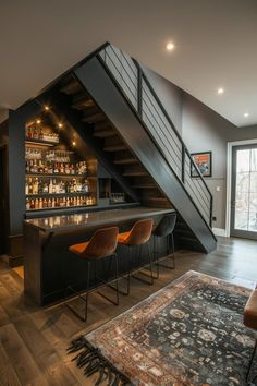 a bar with stools under a stair case next to a rug on the floor