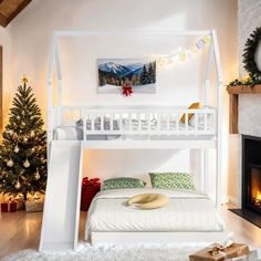 a white bunk bed sitting next to a christmas tree in a living room with a fire place