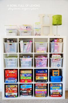 a white bookcase filled with lots of books and plastic containers on top of it