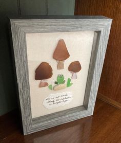 a framed artwork with three mushrooms on it