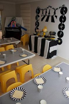 a room filled with tables and chairs covered in black and white tablecloths next to a window