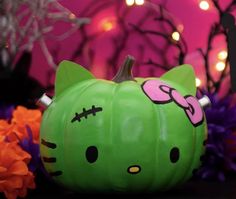 a green hello kitty pumpkin sitting on top of a table