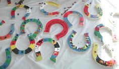 many different colored letters are laid out on a white tablecloth with scissors and other items