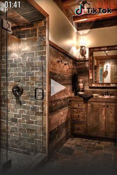 a bathroom with a brick wall and stone flooring is shown in this image, the shower door is open