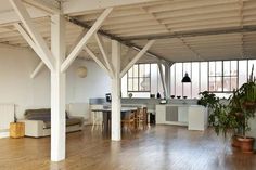 an empty room with wooden floors and white walls, has plants in pots on the floor