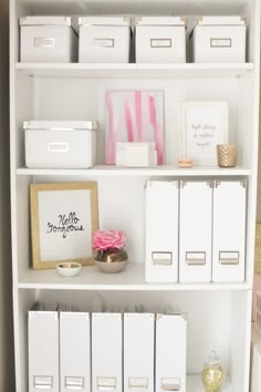 a white book shelf filled with lots of boxes and file folders on top of it