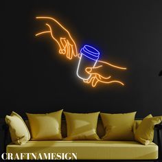 a neon sign that is on the side of a wall next to a yellow couch