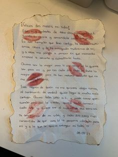 a piece of paper with writing on it and two red lipstick imprints in the middle