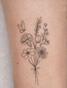 a tattoo with flowers and butterflies on the side of her leg, which is drawn in black ink