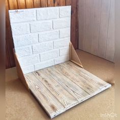 a white brick wall sitting on top of a floor next to a wooden paneled door