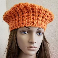 a mannequin head wearing an orange knitted hat